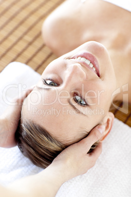 Smiling blond woman receiving a head massage