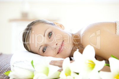 Charming woman lying on a massage table looking at the camera
