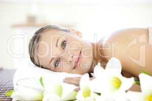 Charming woman lying on a massage table looking at the camera