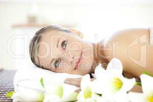Glowing young woman lying on a massage table