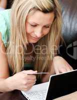 Portrait of a beautiful woman holding a card using her laptop