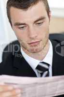 Portrait of a serious businessman reading the newspaper