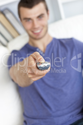 Happy young man holding a remote looking at the camera