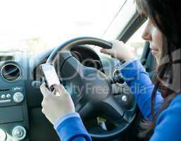 Beautiful brunette woman using her cellphone while driving