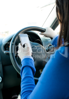 Young brunette woman using her cellphone while driving