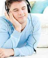 Relaxed young man listen to music with headphones