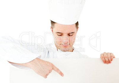 Young caucasian cook showing on a white placard