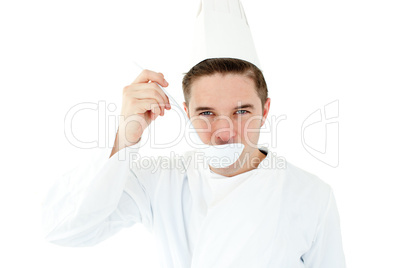 Ambitious male cook tasting a soup