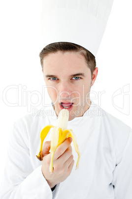 Confident male cook eating a banana