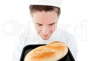 Handsome male cook smell at a fresh bread