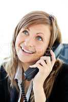 Radiant businesswoman talking on phone in her office
