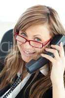 Cheerful young businesswoman talking on phone wearing glasses