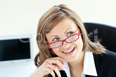 Charming businesswoman sitting on a chair wearing glasses