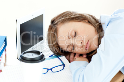 Tired caucasian businesswoman sleeping on her desk