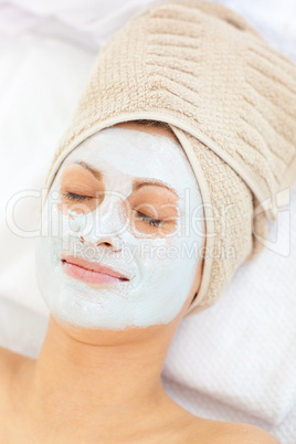 Young woman with white cream on her face and closed eyes