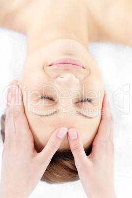 Smiling young woman enjoying a facial massage