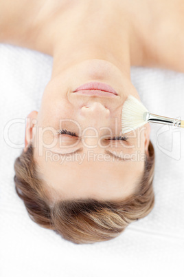 Happy young woman receiving a beauty treatment