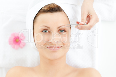 Charming woman using tweezers