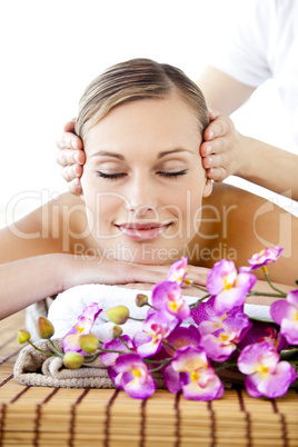 Portrait of a positive young woman receiving a head massage