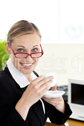 Confident businesswoman drinking a coffee looking at the camera