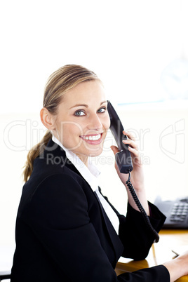 Pretty caucasian businesswoman talking on phone looking at the c