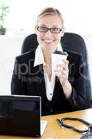 Delighted caucasian businesswoman holding a coffee smiling at th