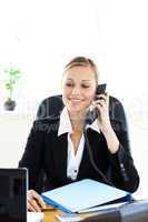 Self-assured businesswoman talking on phone in her office