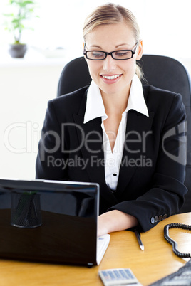 Busy young businesswoman using her laptop in the office