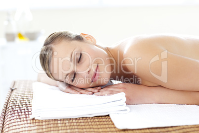 Glad young woman lying on a massage table