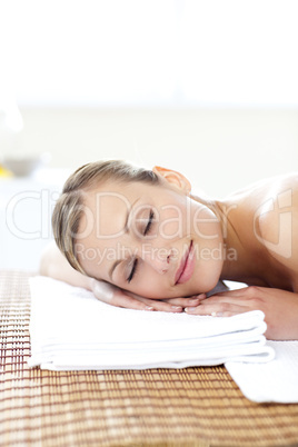 Glowing young woman lying on a massage table