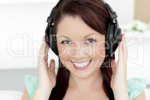 Happy young woman listen to music looking at the camera