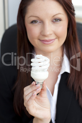 Charismatic businesswoman holding a light bulb