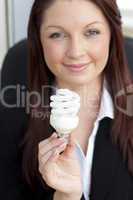 Charismatic businesswoman holding a light bulb