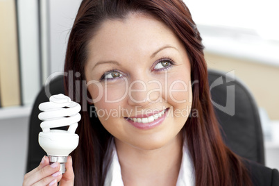 Delighted businesswoman holding a light bulb