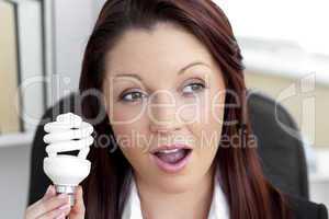 Surprised businesswoman holding a light bulb