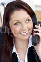 Glowing young businesswoman talking on phone