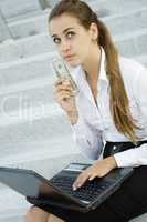Business woman with money and a laptop