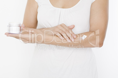 Frau trägt Creme auf ihren Arm auf