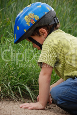 Kind mit Helm gräbt