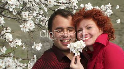 Love couple sniffing flowers