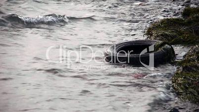 Old tyre in dirty polluted sea - Environment - Pollution