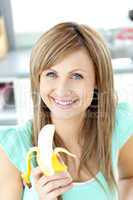 Smiling young holding a banana looking at the camera