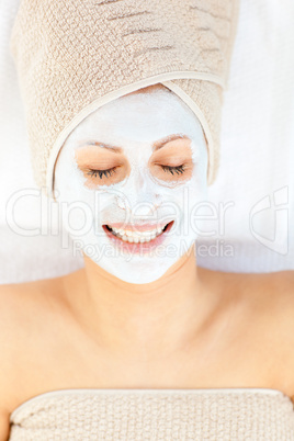 Joyful woman with closed eyes and white cream on her face