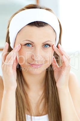 Portrait of a beautiful woman putting moisturizer on her face