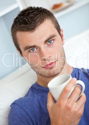 Portrait of a serious young man looking at the camera holding a