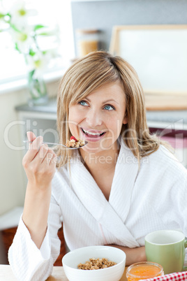 Bright woman eating cereals wearing a bath robe