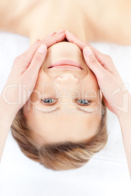 Happy young woman enjoying a facial treatment