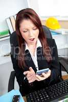 Astonished businesswoman looking at her calculator