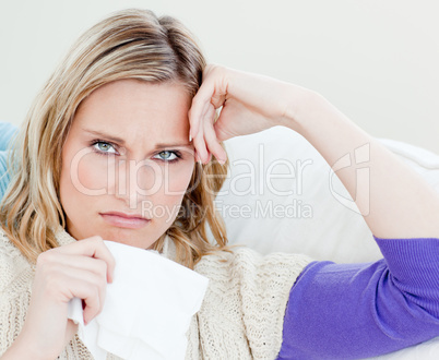 Unhappy sick woman holding tissues looking at the camera