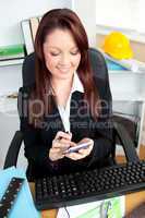 Smiling young businesswoman using her calculator
